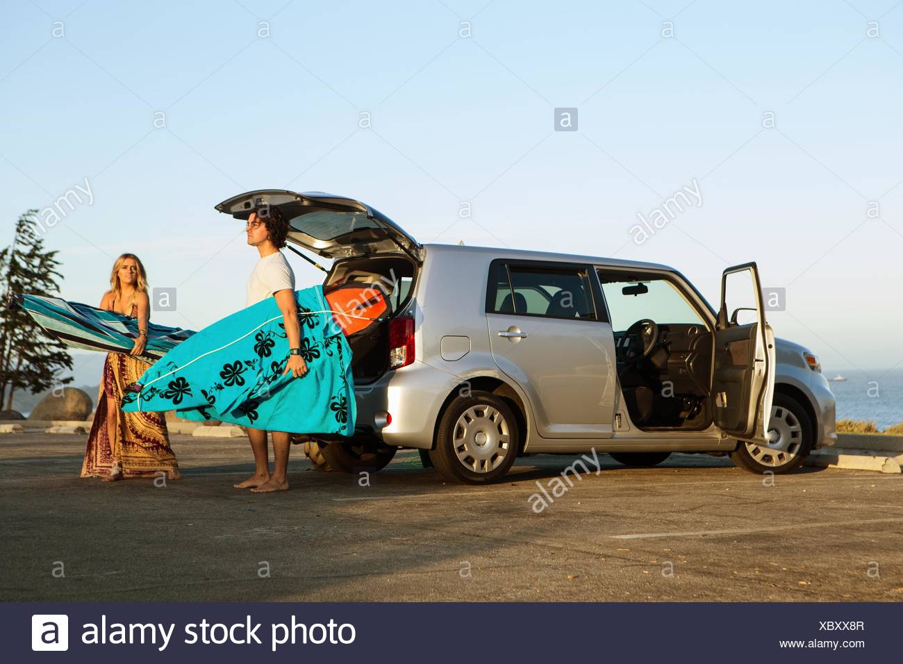 Par tomar las tablas de surf desde el maletero de un coche Foto de stock