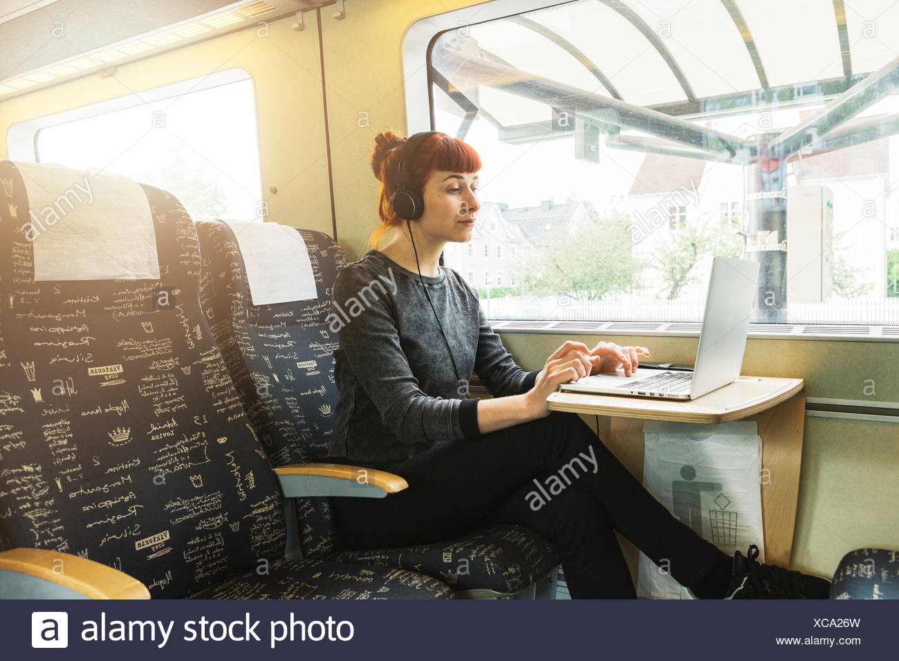 Mujer usando el portátil en el tren Foto de stock