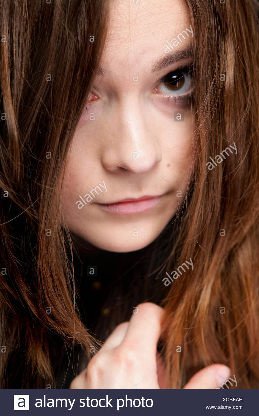Close-up retrato de una bella mujer cubre el rostro por largos pelos marrones Foto de stock