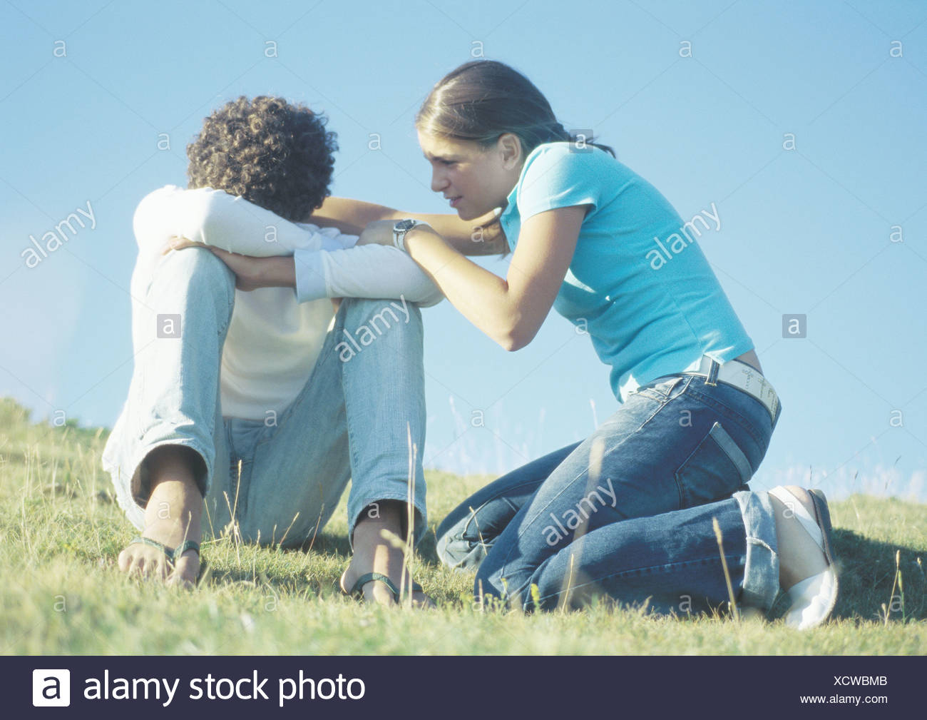 La pareja de adolescentes, niña tratando de hablar con el niño con la cabeza hacia abajo Foto de stock