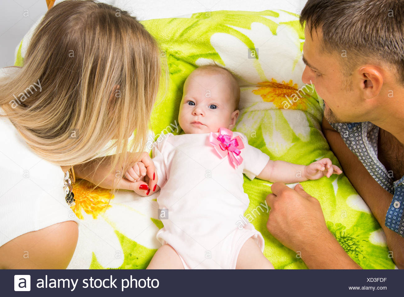 Mama Y Papa Estan Mirando A Un Bebe De Dos Meses Que Esta Tumbada En La Cama Fotografia De Stock Alamy