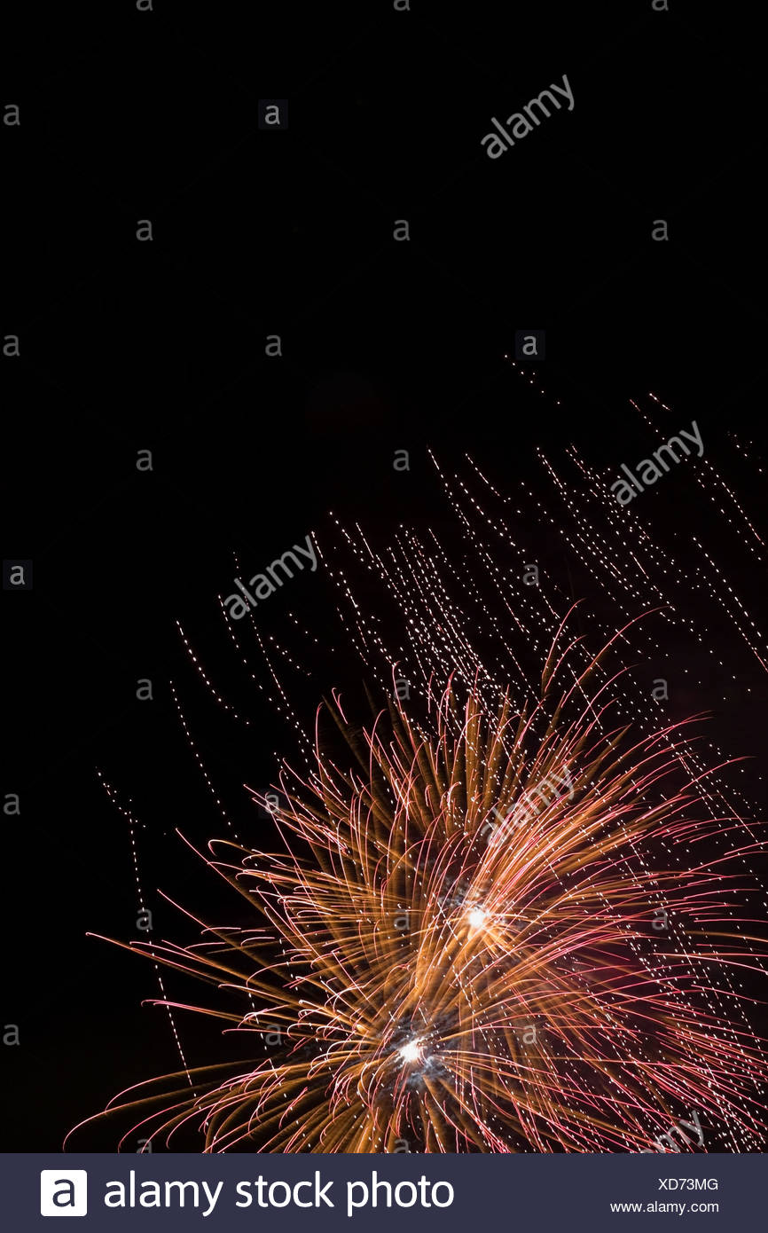 Explosión de fuegos artificiales contra el cielo nocturno Foto de stock
