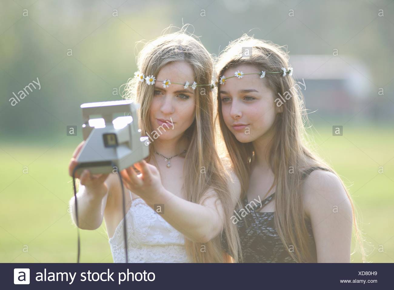Dos chicas adolescentes en estacionamiento teniendo cámara instantánea selfie Foto de stock