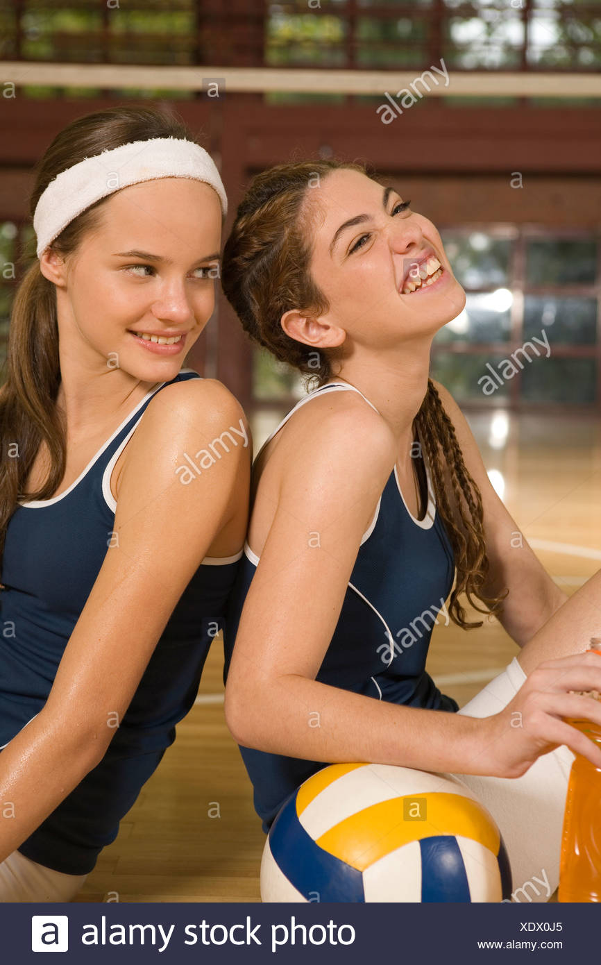 El Perfil Lateral De Dos Jovenes Mujeres Sentadas En Una Cancha De Voleibol Y Sonriente Fotografia De Stock Alamy