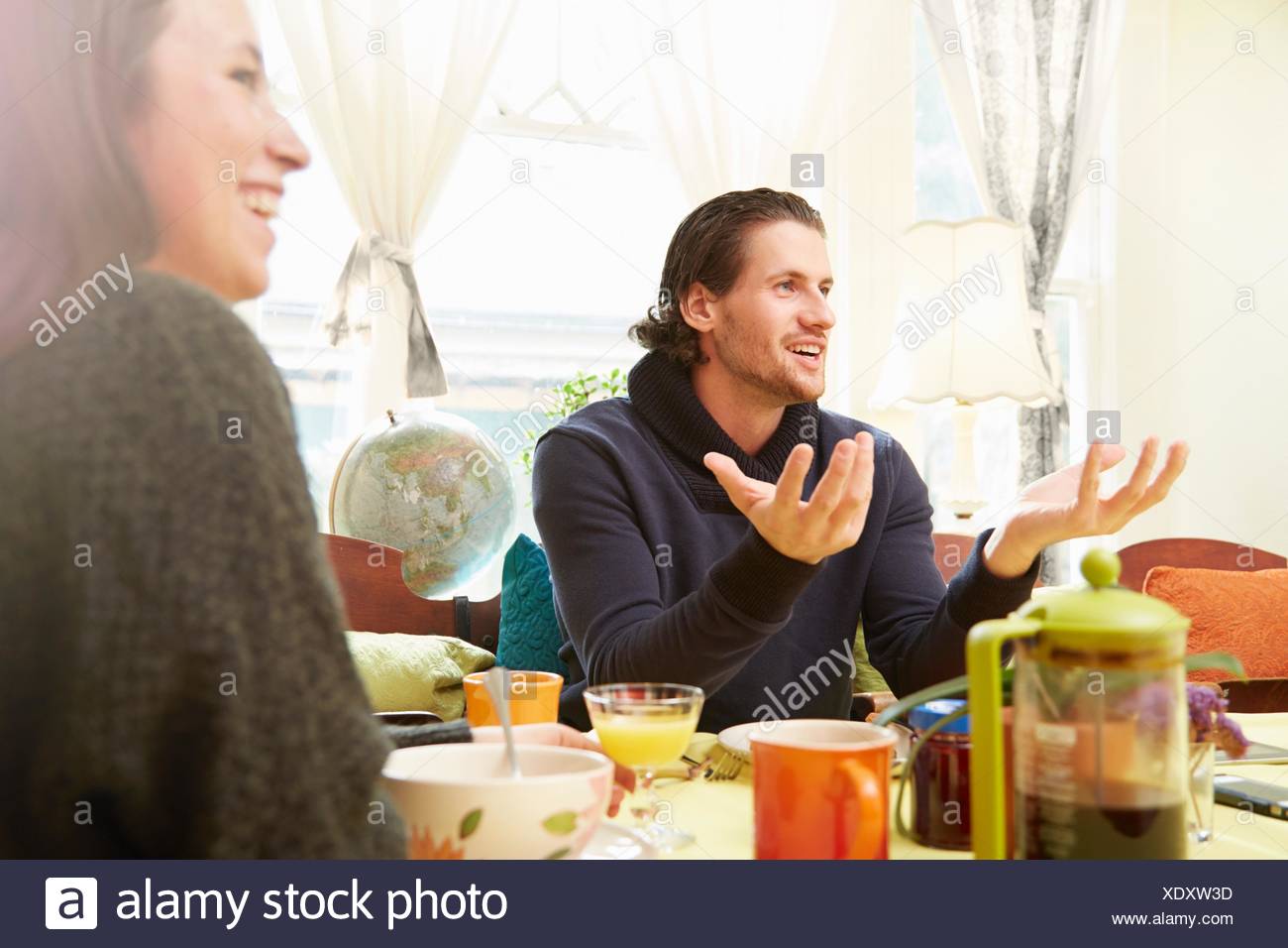 Vista sobre el hombro del joven, explicar con mesa de desayuno Foto de stock