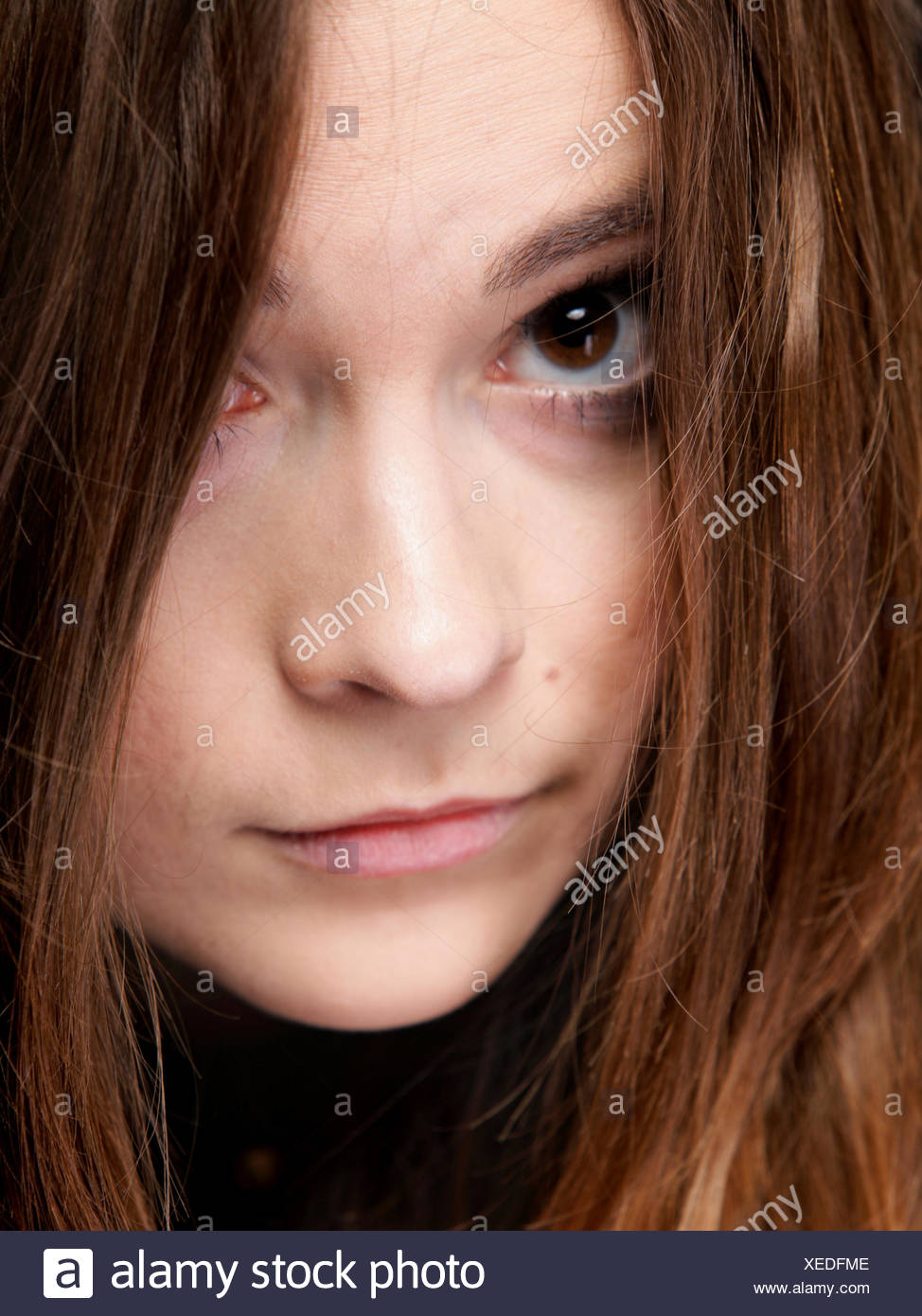 Closeup mujer cubre el rostro por largos pelos marrones Foto de stock