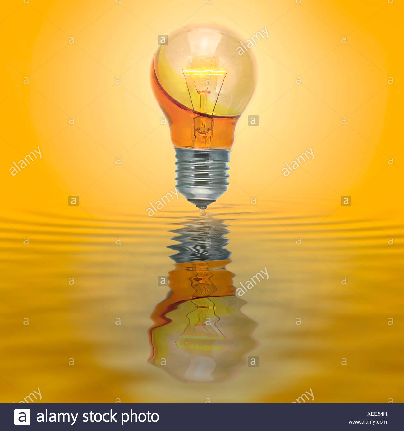 Bombilla ilumine con ninguna conexión eléctrica llena con agua amarilla. Foto de stock