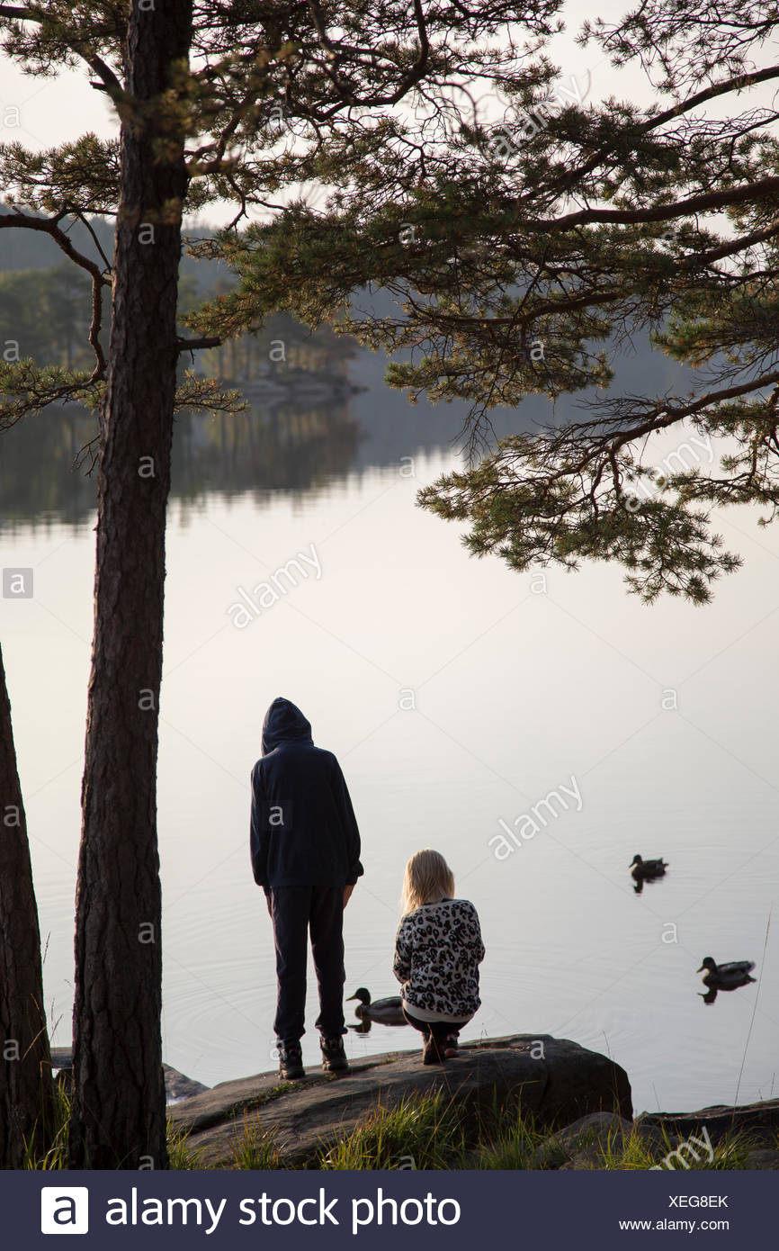 Suecia, Vastergotland, Harskogen, Stora Harsjon, Chico y chica (12-13) (10-11) por el lago Foto de stock