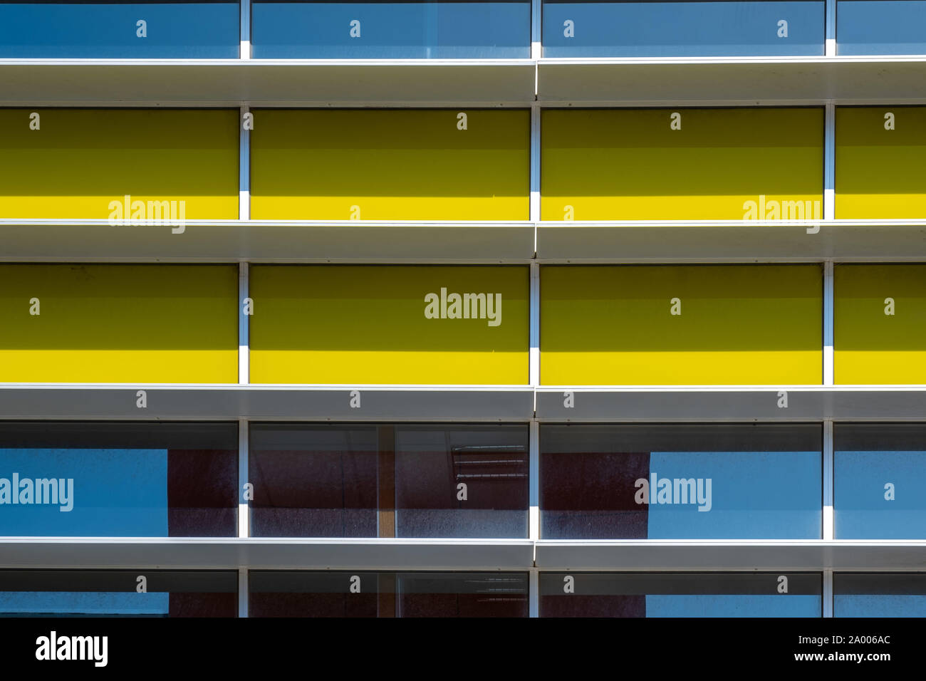 Façade d'un bâtiment industriel dans des fragments de lumière naturelle avec des ombres Banque D'Images