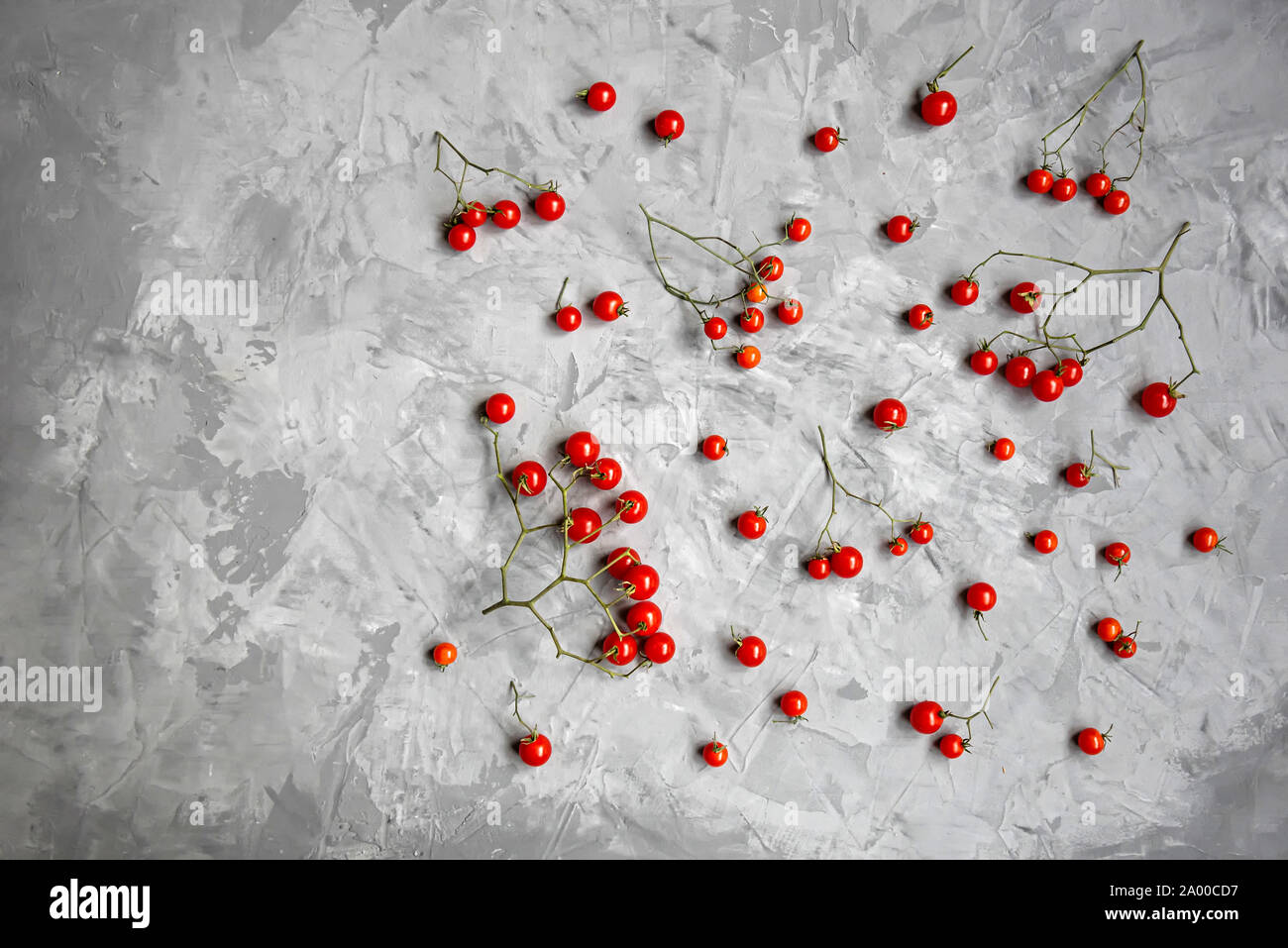 Tomate cerise sur un fond gris. Mise à plat, vue du dessus. Copier l'espace. Banque D'Images