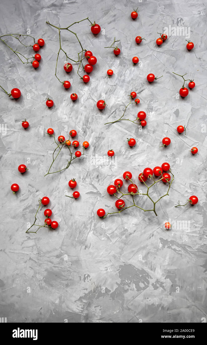 Tomate cerise sur un fond gris. Mise à plat, vue du dessus. Copier l'espace. Banque D'Images
