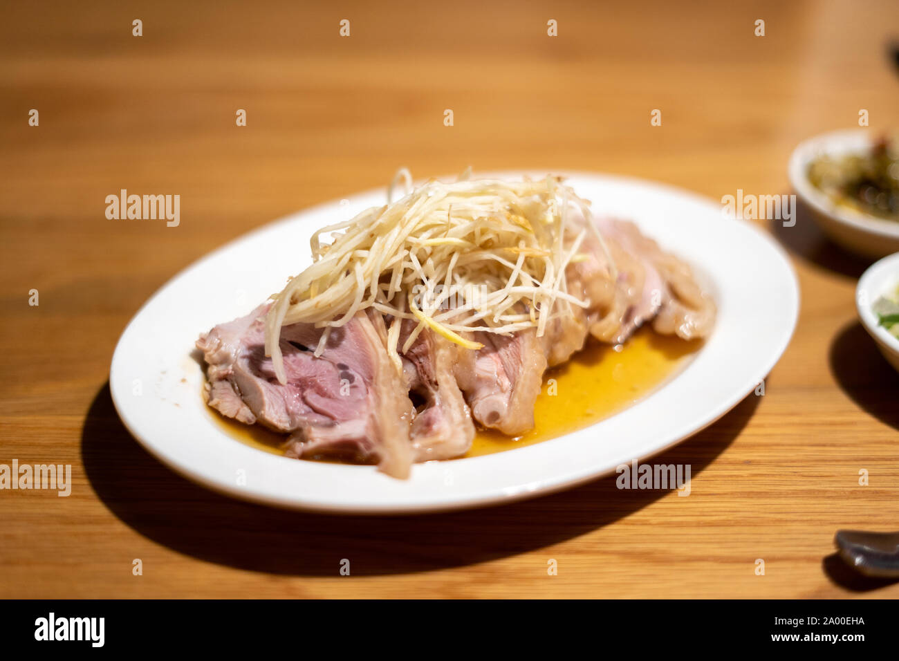 Froid, avec du gingembre poulet style taïwanais sur une plaque blanche sur une table en bois Banque D'Images