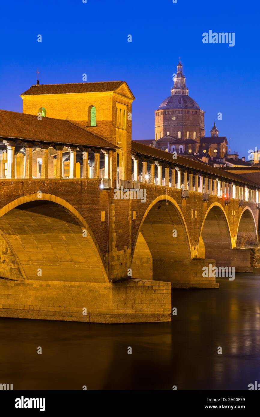 Pont Ponte Coperto lumineux donne sur la rivière Tessin avec cathédrale, crépuscule, Pavie, Lombardie, Italie Banque D'Images