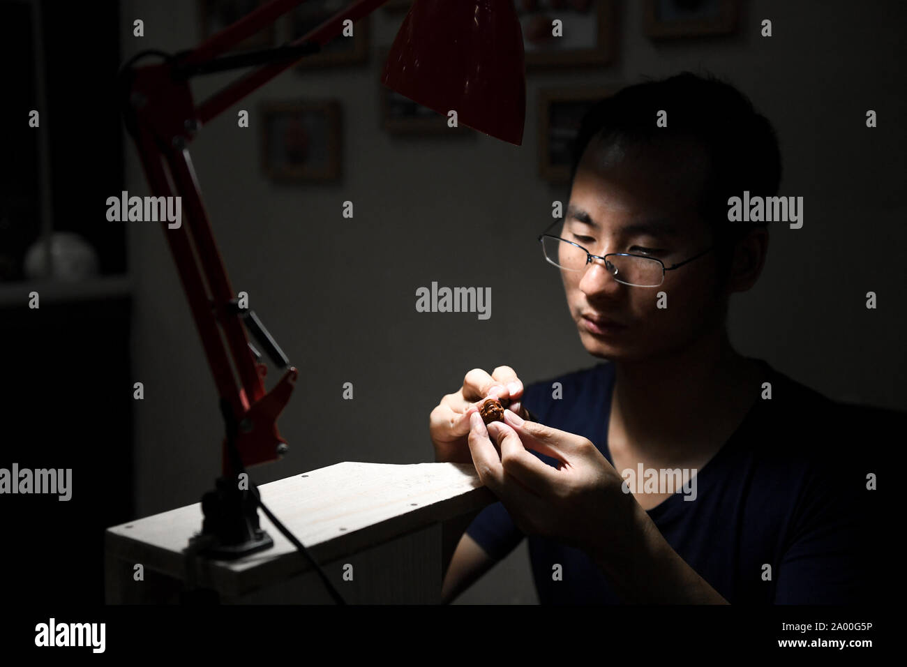 Changsha, Chine, province du Hunan. 18 Sep, 2019. Ma Linyi se concentre sur son travail de sculpture sur fruits pit à Changsha, Province du Hunan en Chine centrale, 18 Septembre, 2019. Ma a commencé l'apprentissage de la sculpture sur fruits pit à 21 ans sous la direction du célèbre artisan Zhou Jianming, un héritier de la patrimoine culturel immatériel national 101 fosse fruits sculpture, et est devenu un remarquable artisan lui-même avec ses œuvres après des années de travail. Crédit : Chen Zeguo/Xinhua/Alamy Live News Banque D'Images