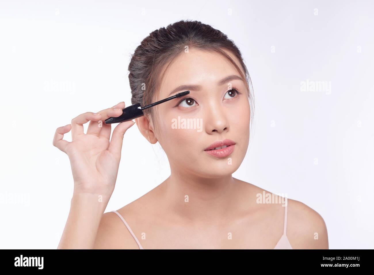 Woman putting Mascara maquillage sur les yeux. Modèle féminin asiatique  face closeup oeil avec la brosse sur les cils Photo Stock - Alamy