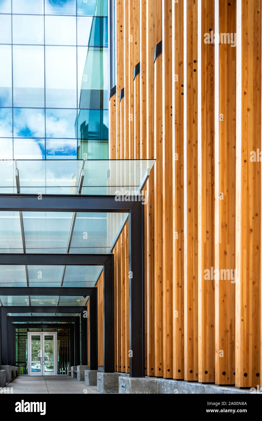 La porte d'entrée du bâtiment avec l'extérieur et structuraux en bois sur  poteaux métalliques pare-soleil en verre et de réflexion de l'ciel nuageux  dans le brillant de windows Photo Stock - Alamy