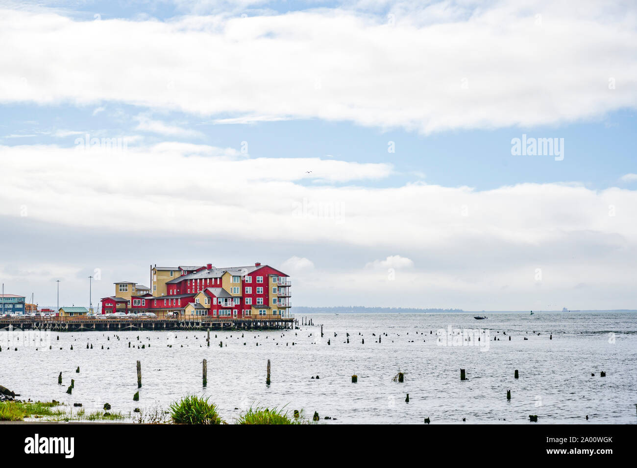 Bâtiment en bois rouge sur l'ancien quai de pêche avec des piles de bois qui dépasse de l'eau à l'échelle de l'embouchure de la rivière Columbia, dans le Pacifique sur la ville Astoria Banque D'Images