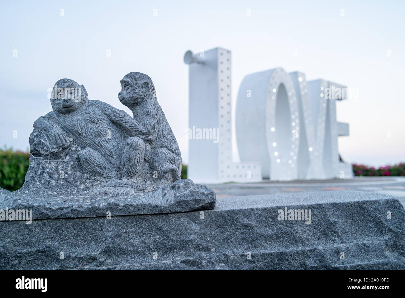 Kaohsiung, Taiwan : une statue de pierre de deux singes dans l'amour le mot amour en lettres géantes avec feux lumineux au Sanctuaire des Martyrs Banque D'Images