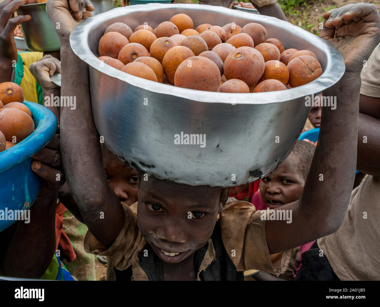 Malawi - jeune enfant vente de fruits à partir d'un bol sur sa tête paraît jusqu'à l'acheteur dans une voiture Banque D'Images