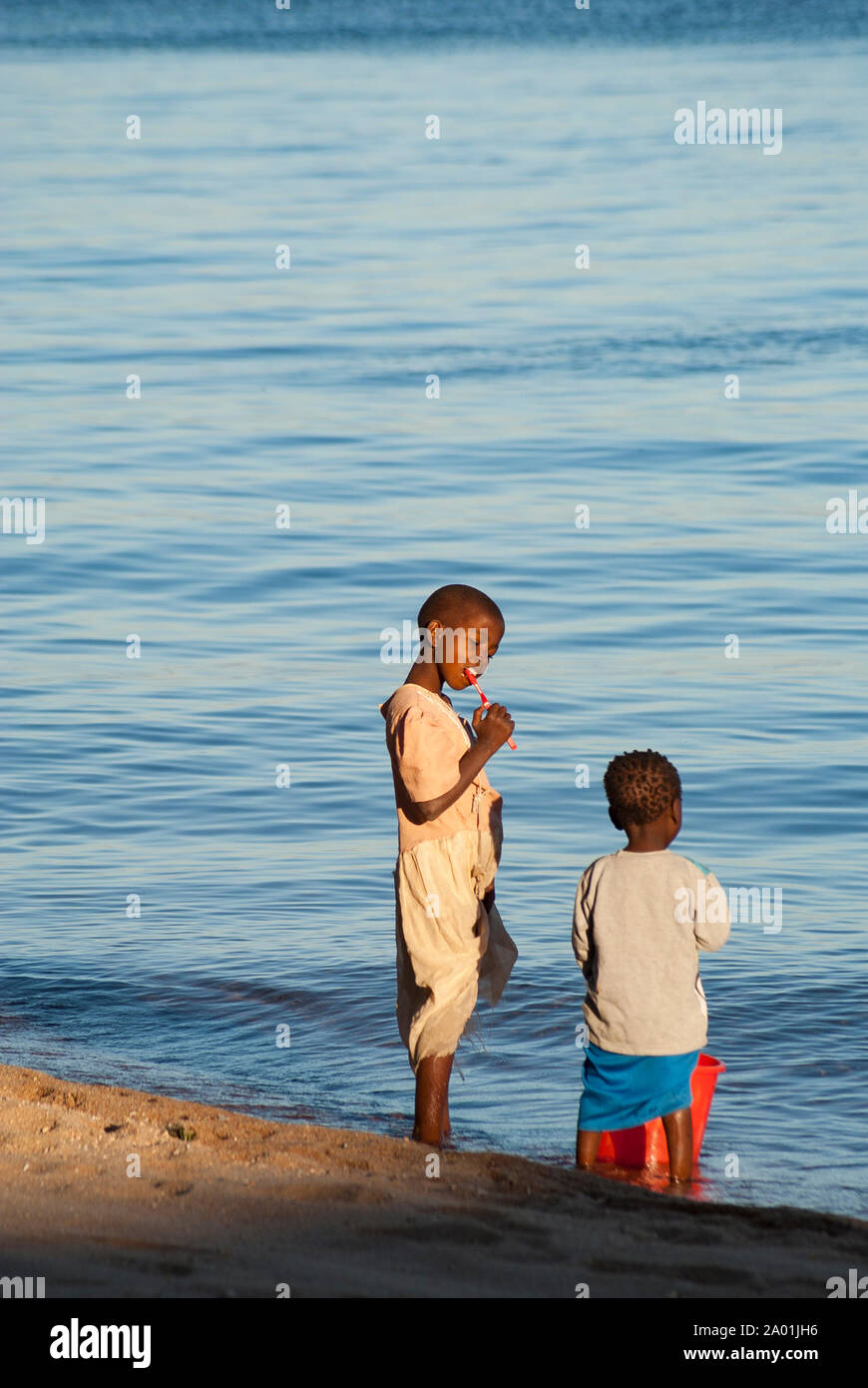 Un jeune enfant sur la rive du lac Malawi brosse les dents Banque D'Images