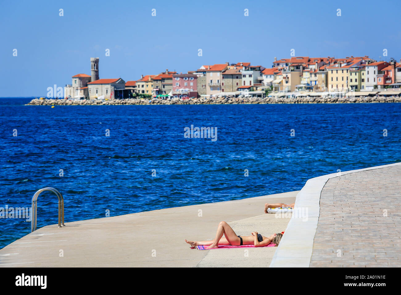 Piran, Istrie, Slovénie - baigneurs à la plage en béton Fornace de la ville portuaire Piran à la mer Méditerranée. Piran, Istrien, Slowenien - Badende Banque D'Images