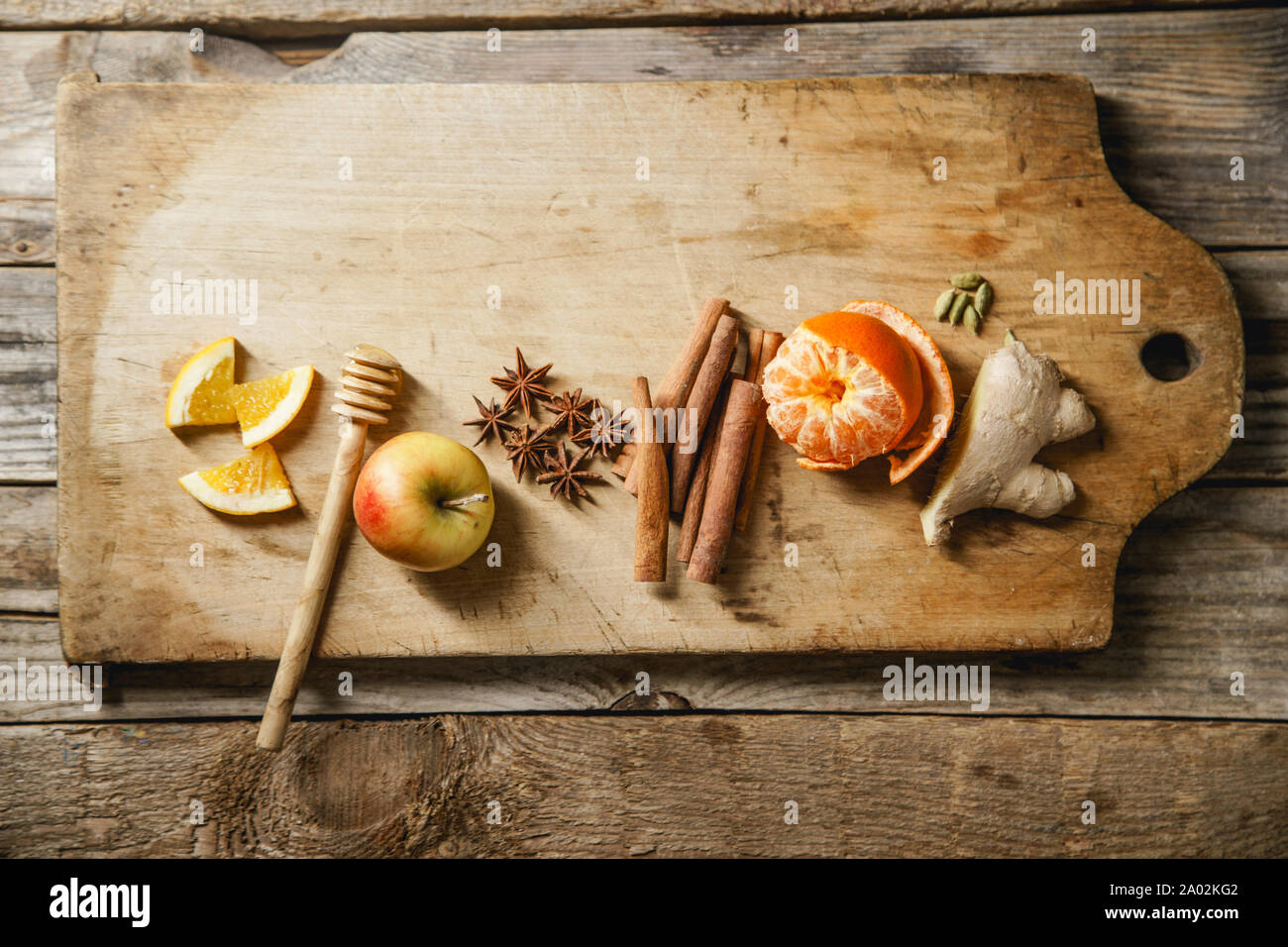 Flatlay avec les ingrédients pour la cuisson du vin. Apple, la mandarine, la cannelle, l'anis étoile, la cardamome et le gingembre sur planche à découper en bois Banque D'Images