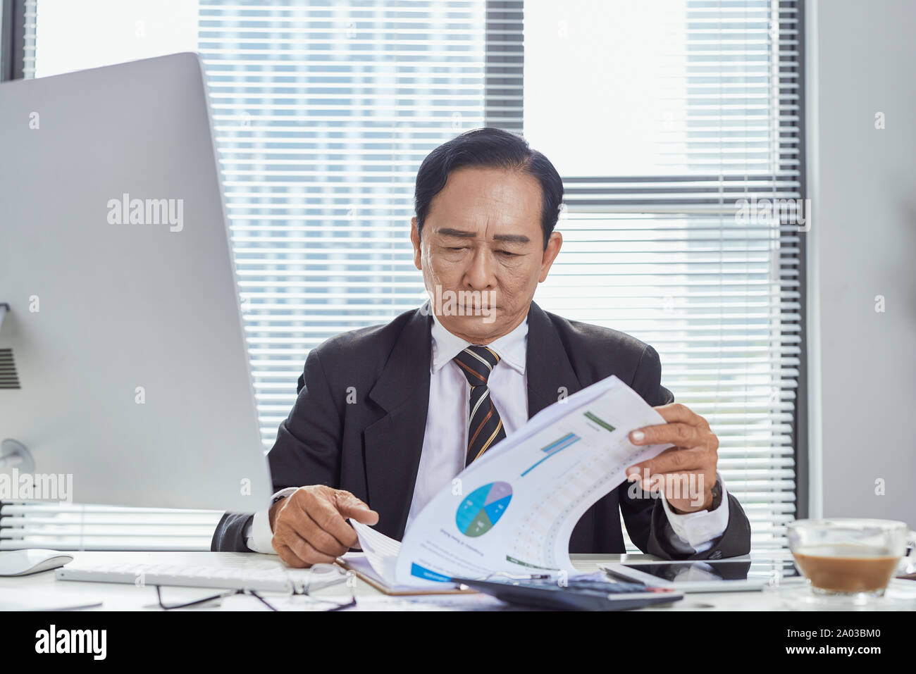 L'accent sur le document de travail asian businessman in office Banque D'Images