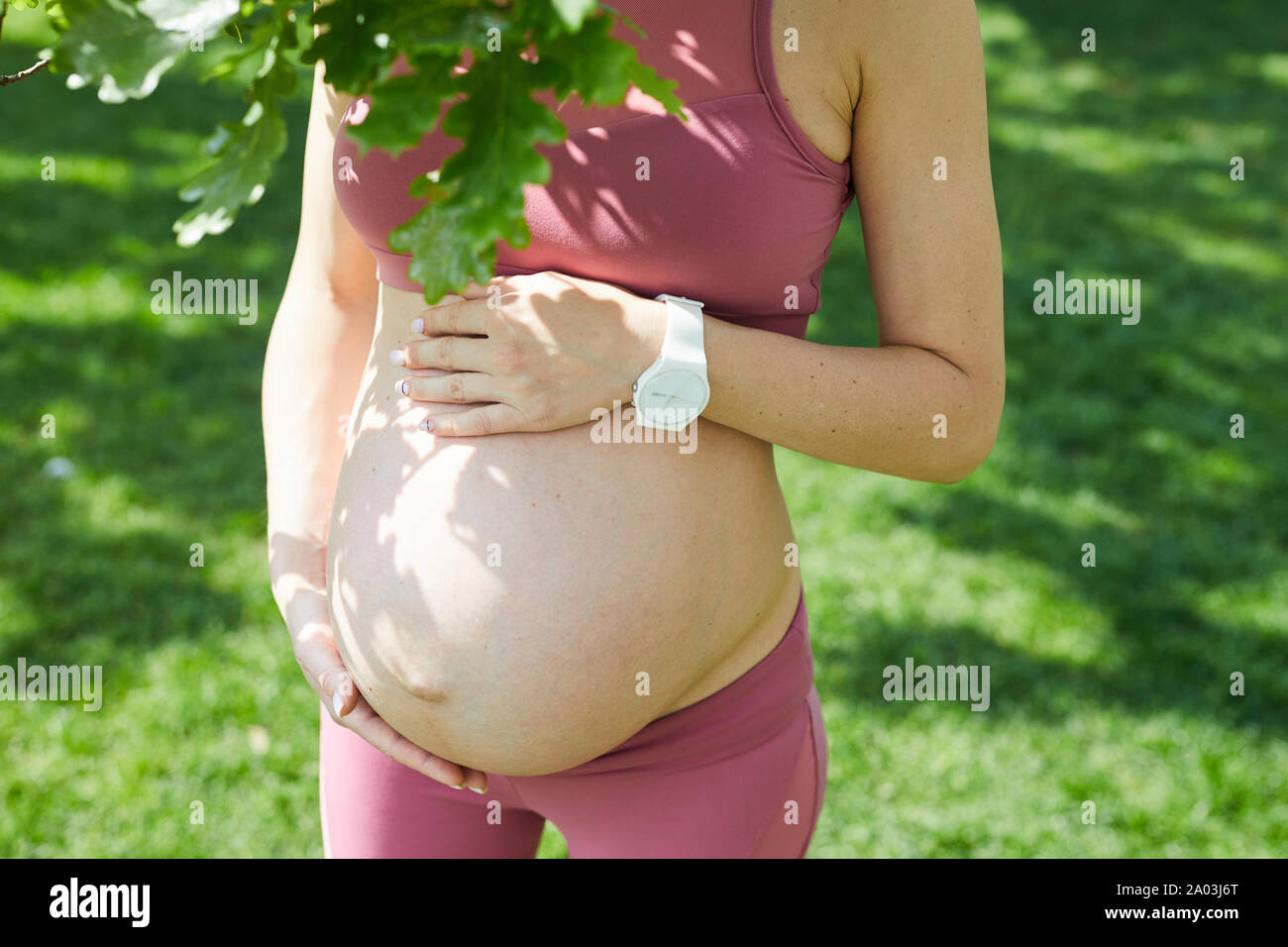 Close-up of young pregnant woman in pink clothing profiter de la nature de l'été et de sa grossesse Banque D'Images