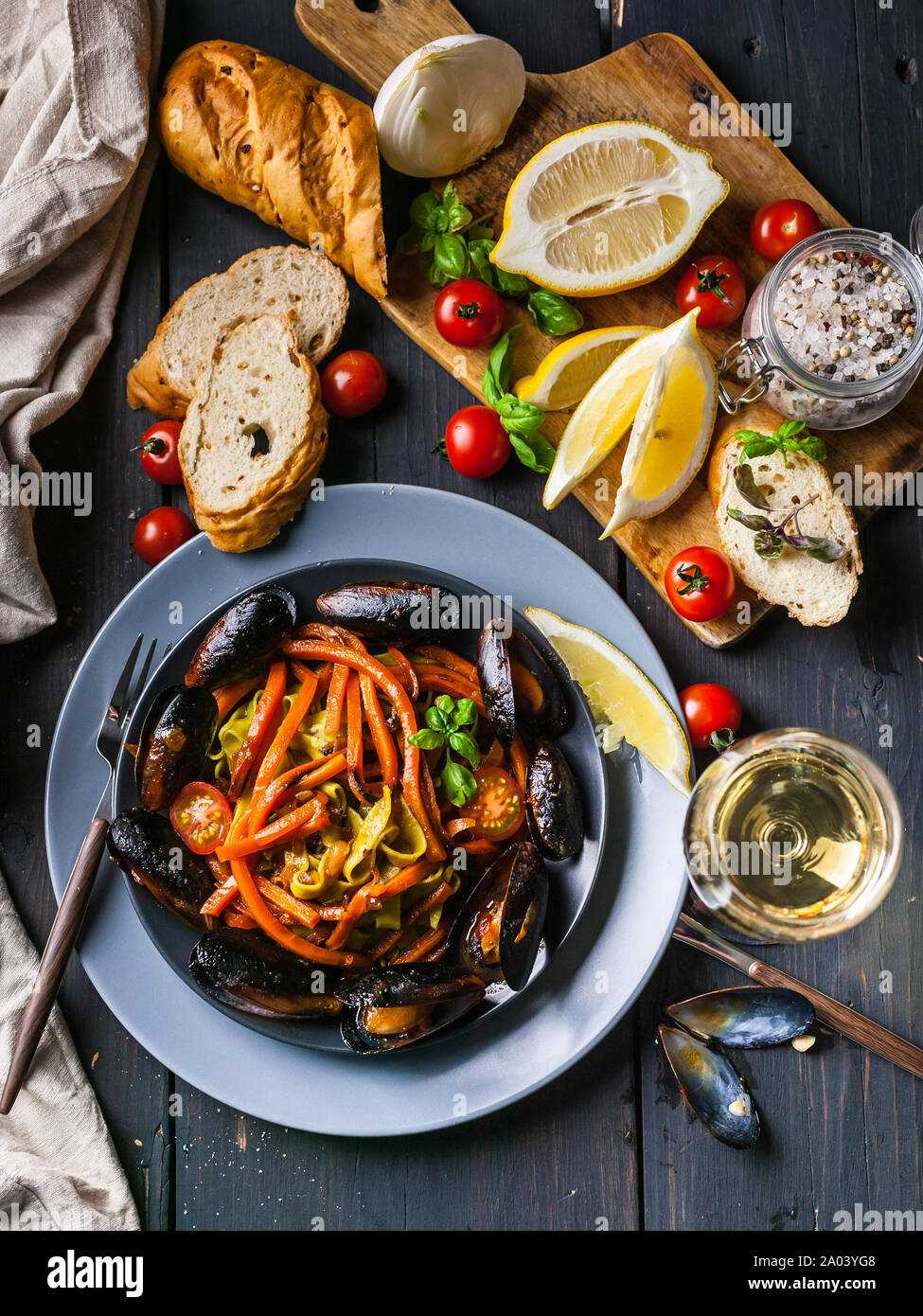 Les moules avec les légumes et spaghetti. Cuisine méditerranéenne. Les fruits de mer et le vin. Shot verticale Banque D'Images