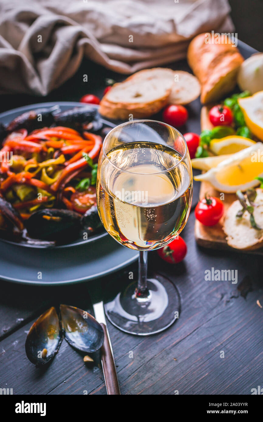 Les moules avec les légumes et spaghetti. Cuisine méditerranéenne. Les fruits de mer et le vin. Shot verticale Banque D'Images