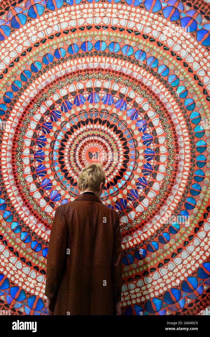 Un homme regarde 'tranquillité' par l'artiste Damien Hirst composé d'ailes de papillon et brillant du ménage sur toile lors de l'exposition au White Cube à Londres. Banque D'Images