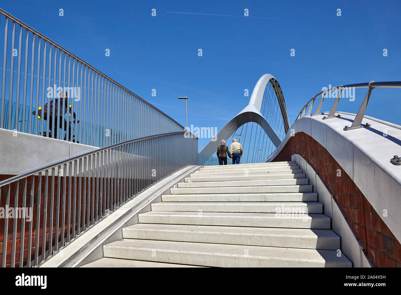 Deux personnes en haut d'un escalier en béton sur le pont d'un pont bowstring nommé De Oversteek qui enjambe la rivière Waal à Nimègue Banque D'Images