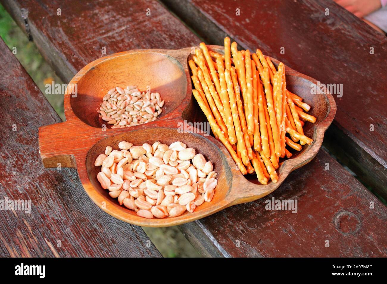 Bol en bois sculpté en forme de feuille avec des écrous et des collations Banque D'Images