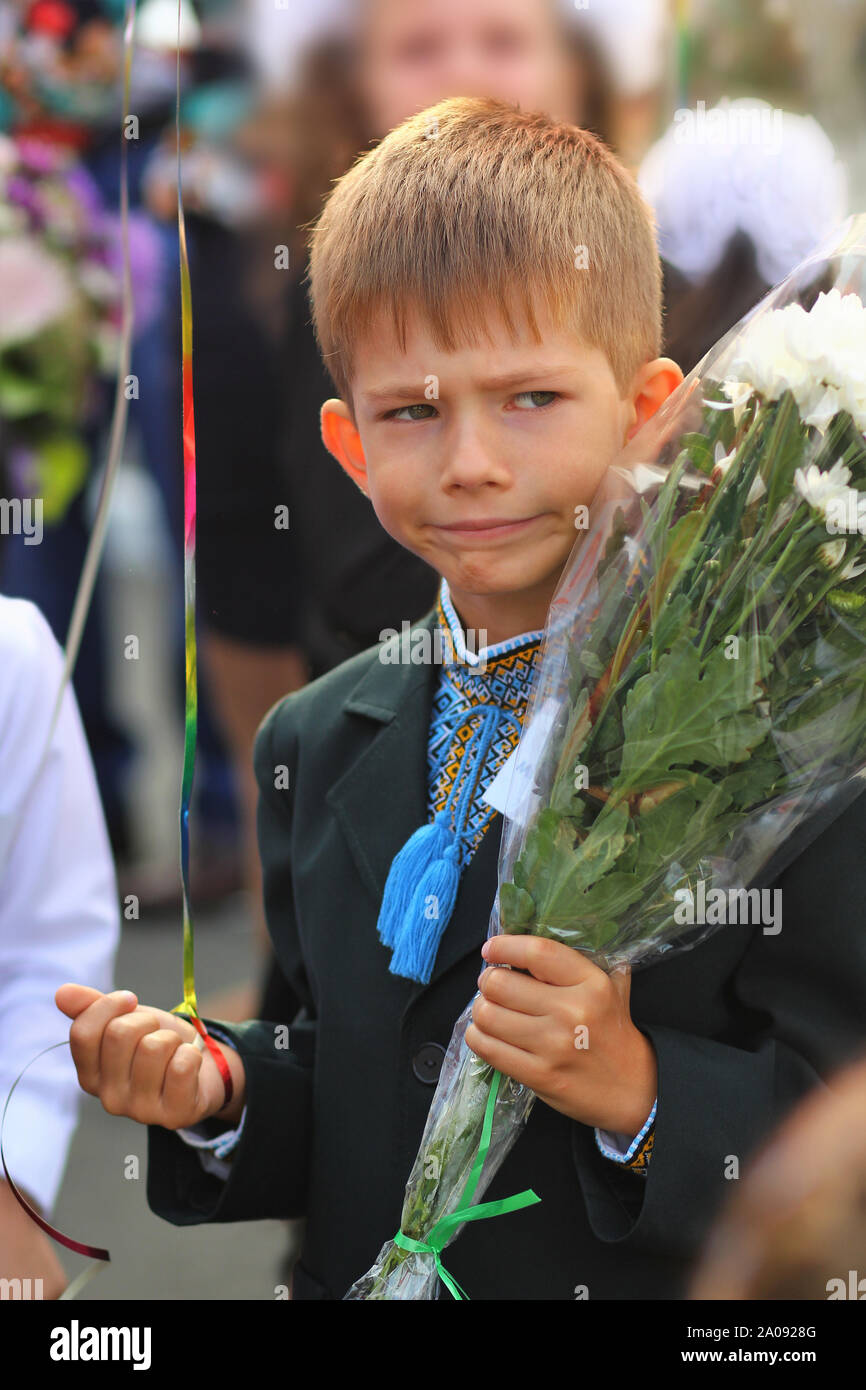 Étudiant de première année drôle avec bouquet de fleurs à sa première journée d'école. Banque D'Images