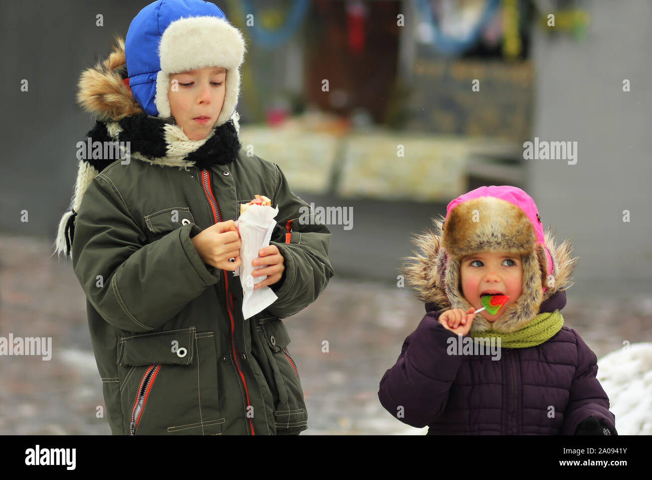 Les enfants de manger des aliments de rue, francs portrait d'hiver Banque D'Images