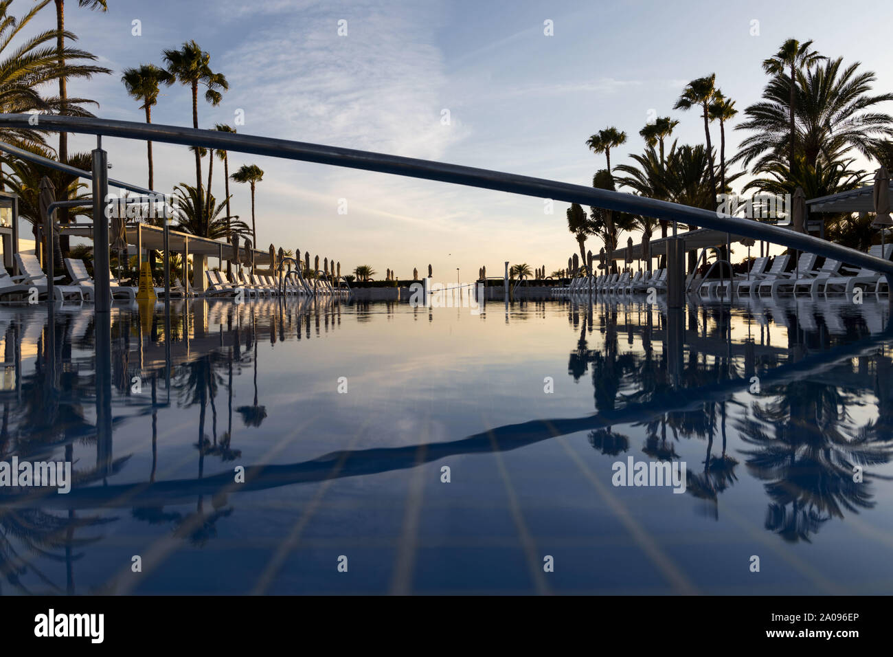 Une belle piscine dans la lumière du soir de Grande Canarie. Les palmiers autour de la piscine créent un sentiment de repos Banque D'Images