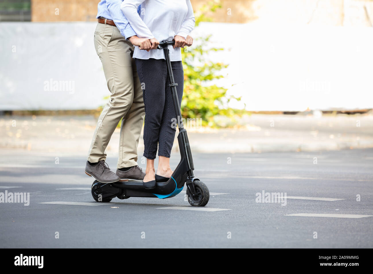 Portrait Of Happy Couple Riding sur scooter électrique sur la rue dans la ville Banque D'Images
