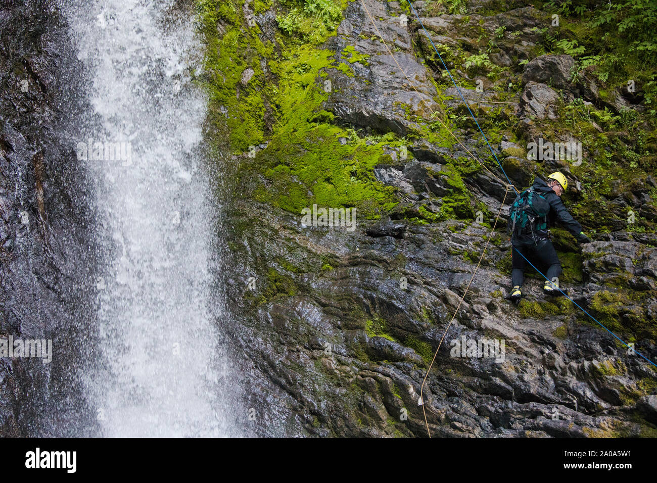 L'homme à côté de la descente en rappel dans la cascade gelée Creek Canyon. Banque D'Images