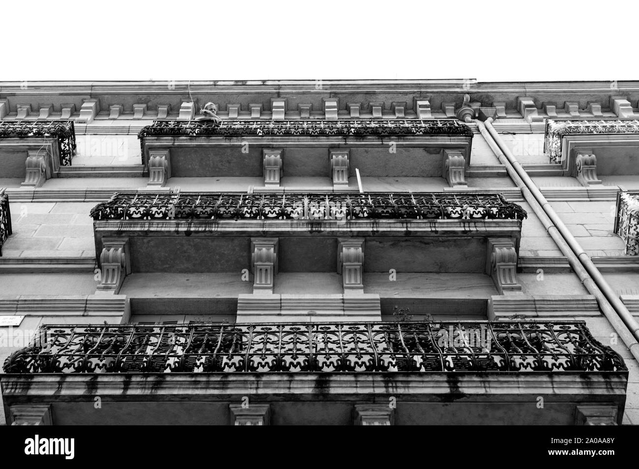 Man smoking a cigarette sur le balcon d'un immeuble à appartements, San Sebastian, Espagne. Banque D'Images