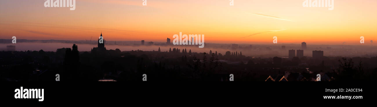 Un panorama de la ville de Leeds au cours d'un lever de soleil brumeux. Banque D'Images