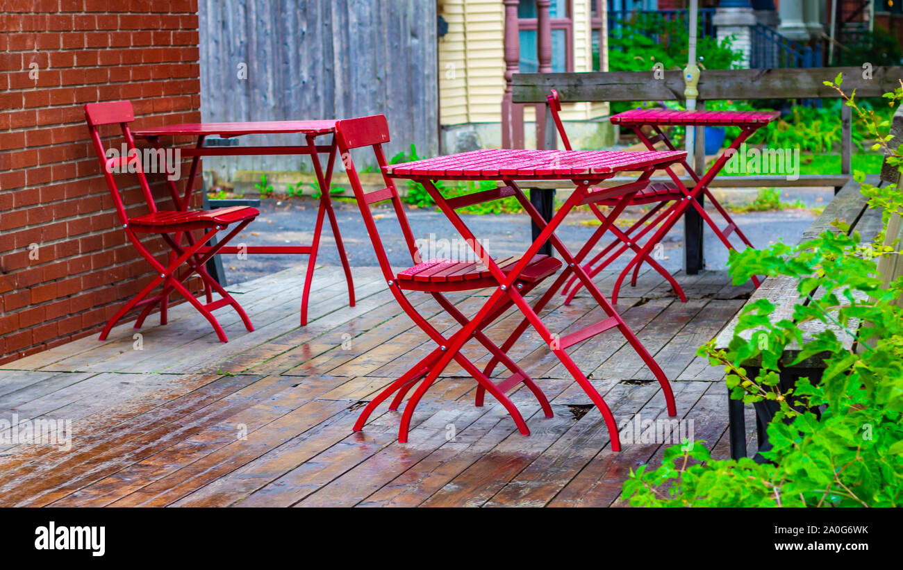 Les tables et les chaises rouges sont à l'extérieur d'un café (hors cadre) sur une terrasse. Banque D'Images