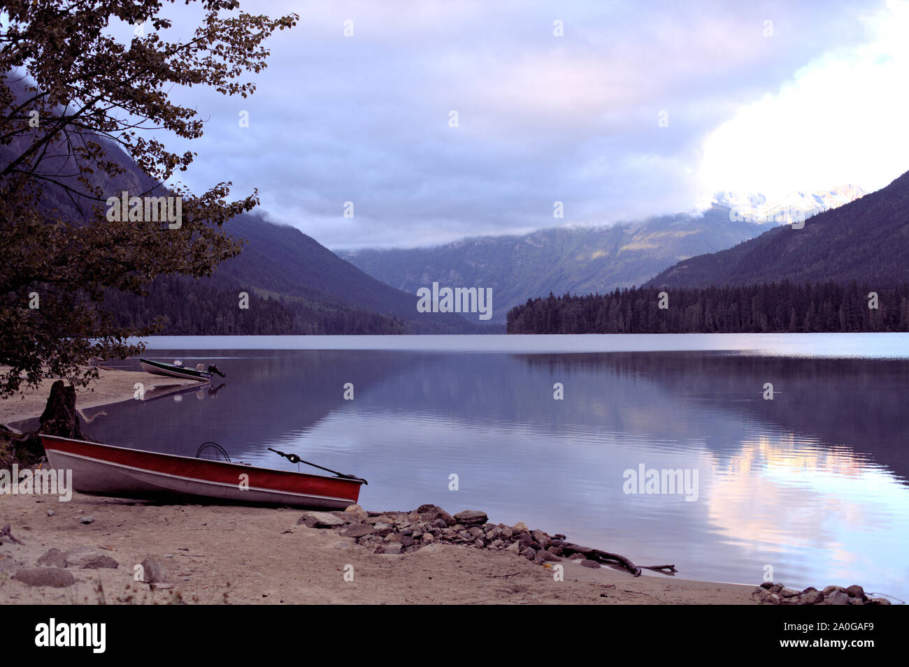 Birkenhead Lake paisible le matin, avec 2 vide bateaux de pêche sur la plage Banque D'Images