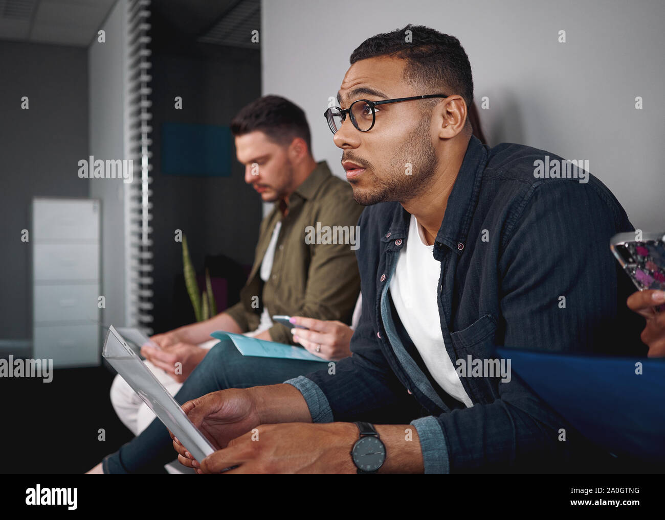Portrait d'un african american man reprendre dans sa main en attente d'entrevue d'emploi avec d'autres candidats dans l'entreprise - du vrai foi Banque D'Images
