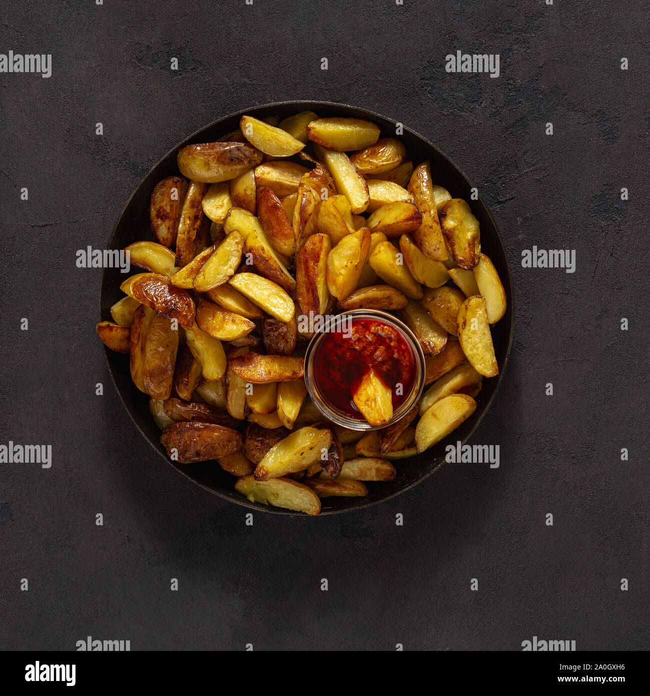 Frites avec sauce brava sur un fond sombre avec copie espace Vue de dessus Banque D'Images