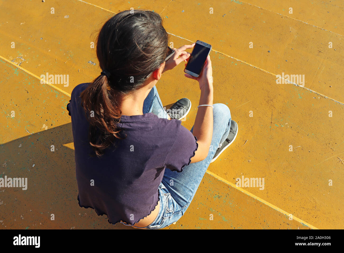 Jeune fille regardant smart mobile phone Banque D'Images