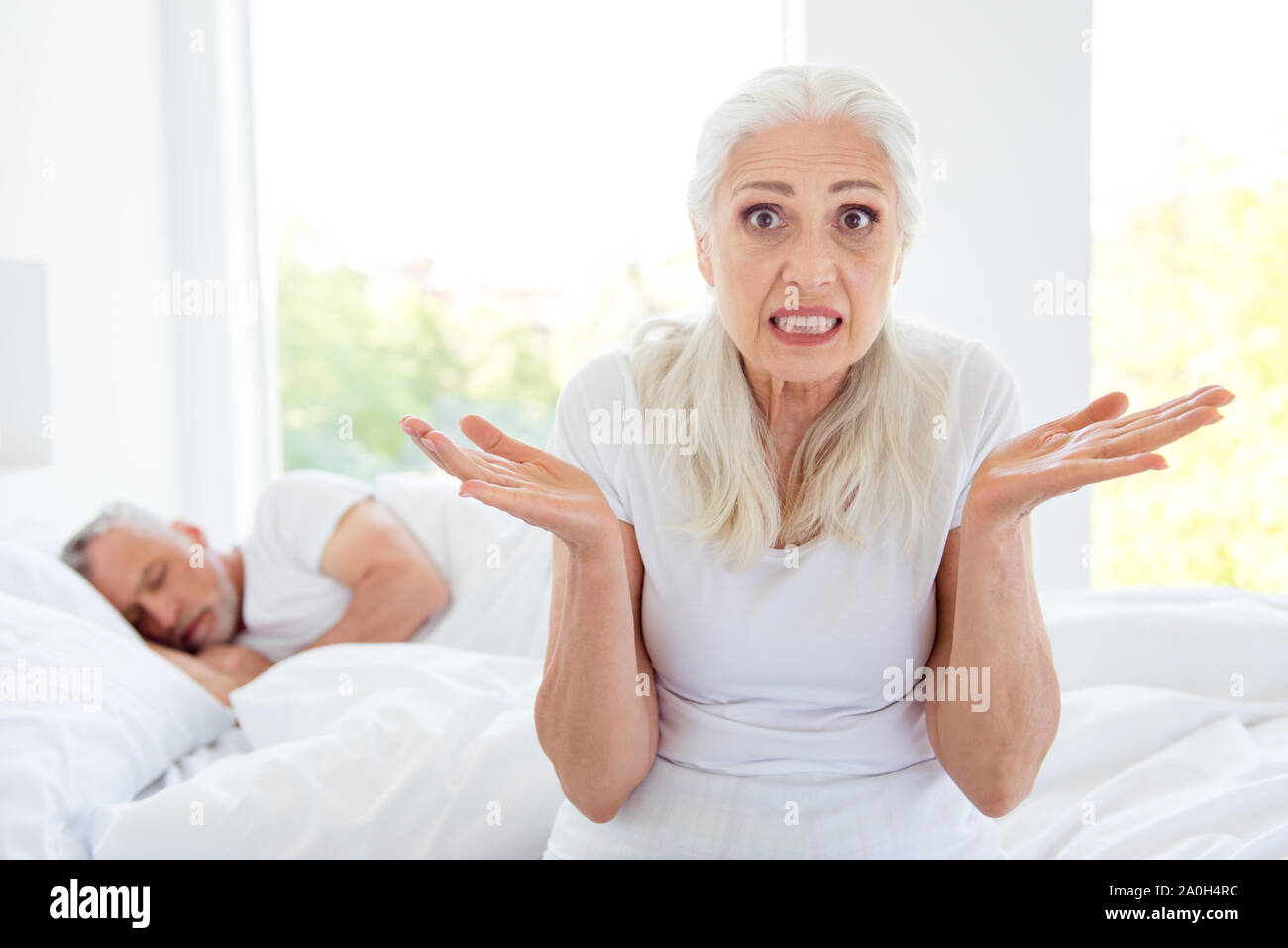 Portrait de grey haired Vieux nice belle femme étonné déçu choqués posées paumes s'asseoir dans pajama, le sommeil, l'usure, de vêtements, vêtements de nuit près de daydre Banque D'Images Portrait de grey haired Vieux nice belle femme étonné déçu choqués posées paumes s'asseoir dans pajama, le sommeil, l'usure, de vêtements, vêtements de nuit près de daydre Banque D'Images