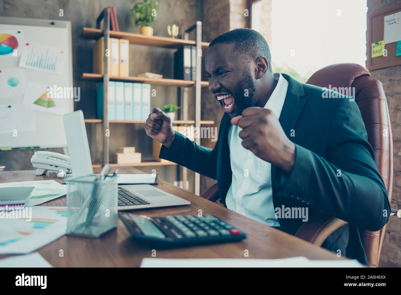 Vue latérale du profil élégant élégant beau fou furieux, l'homme d'affaires shark mulato en veste, panique sur le lieu de travail, d''un poste de travail Banque D'Images