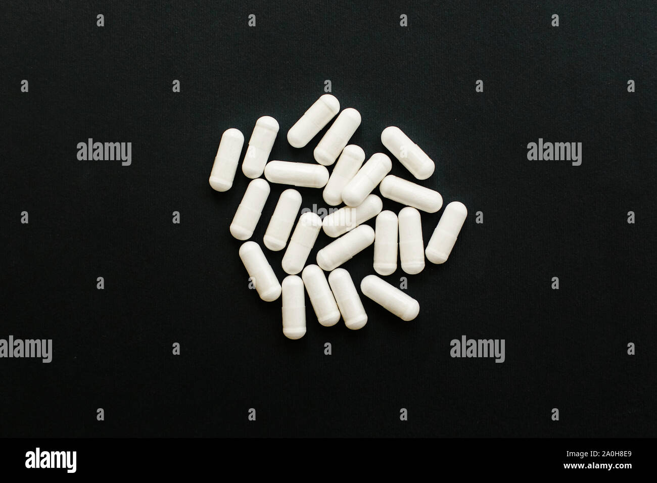 Gélules de magnésium noir sur fond sombre. Mise à plat. Les suppléments alimentaires. Comprimé blanc. L'appui de la santé et de traitement. Additifs biologiquement actifs. Banque D'Images