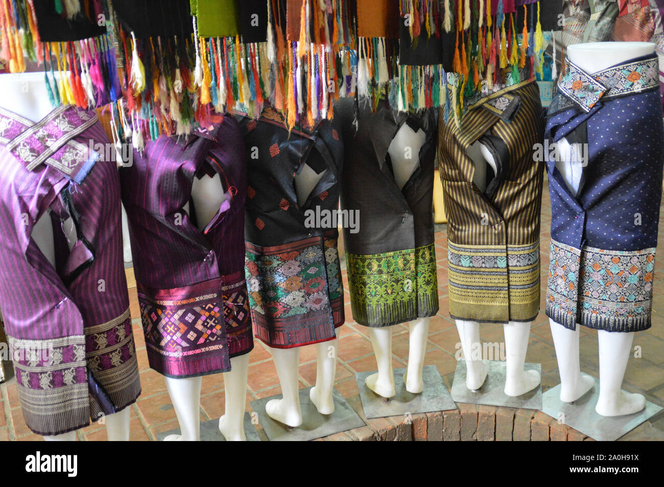 Les Silks laotiens traditionnels se sont vendus comme souvenirs touristiques sur un affichage mannequin sur le marché nocturne de Luang Prabang, au Laos Banque D'Images