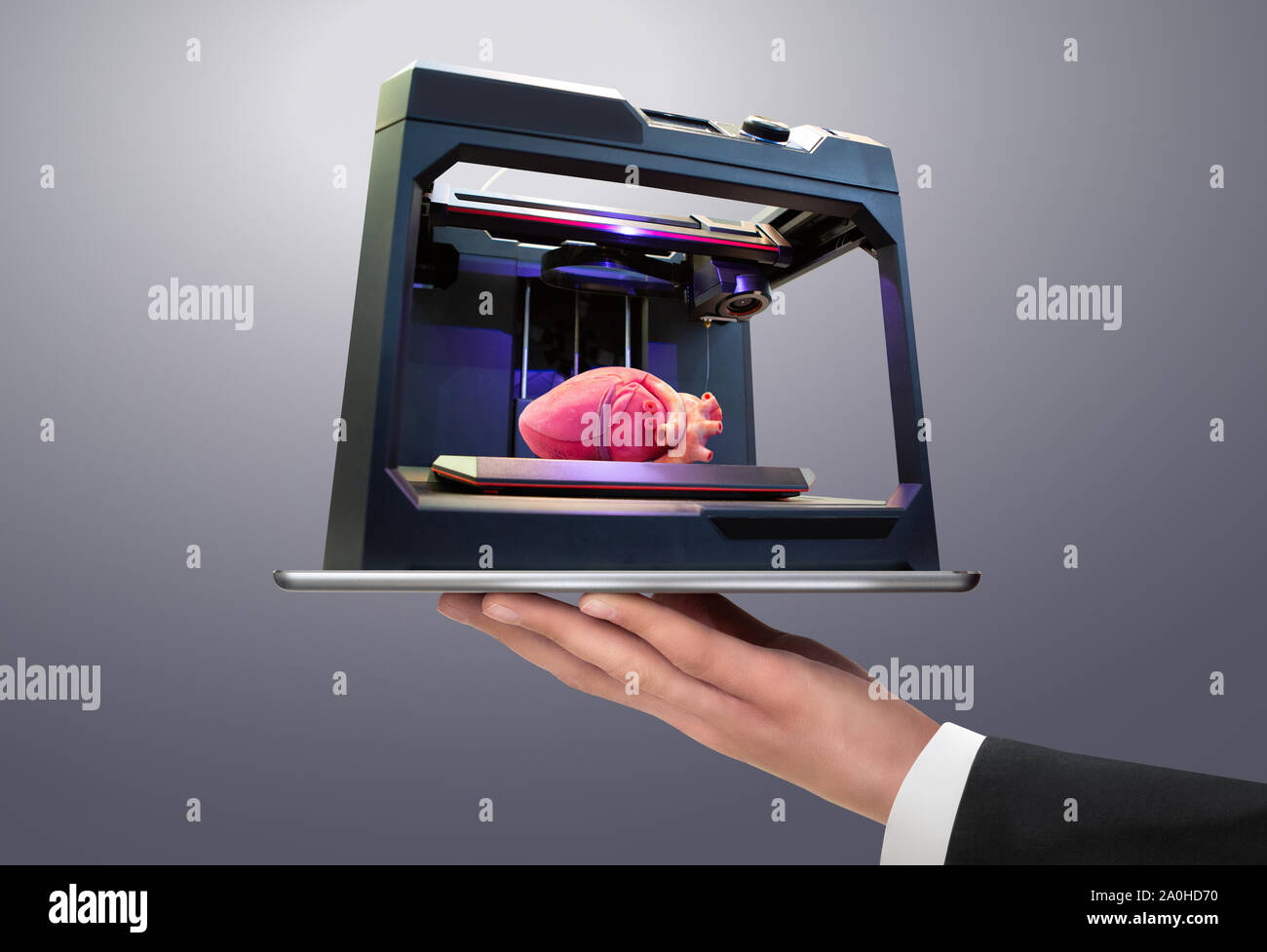 Homme tenant une tablette numérique avec imprimante 3d avec un cœur humain imprimé Banque D'Images
